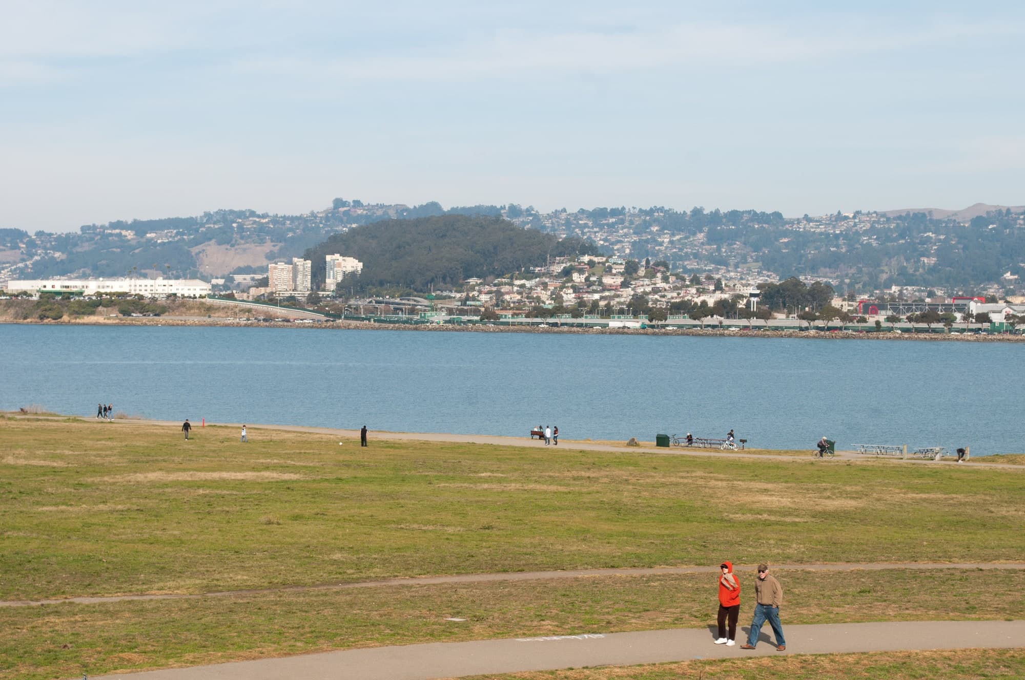 People walking through a park near the bay