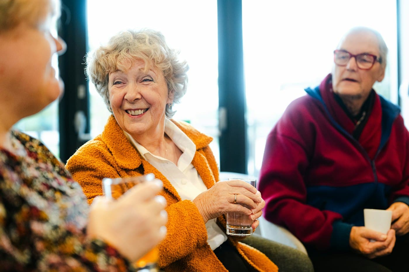 Older adults smiling and chatting together at a community gathering