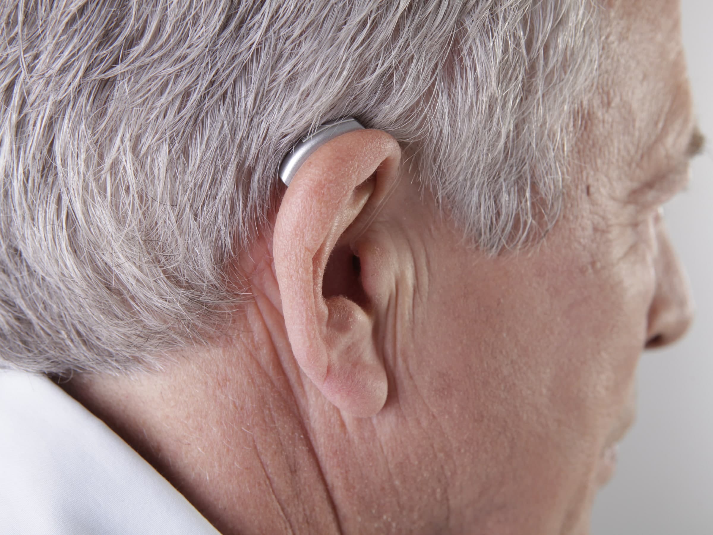 Mature adult wearing a hearing aid.